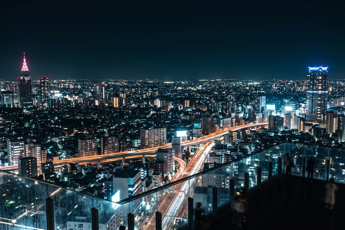 Tokyo at night seen from the Shibuya Sky rooftop, city lights to the horizon